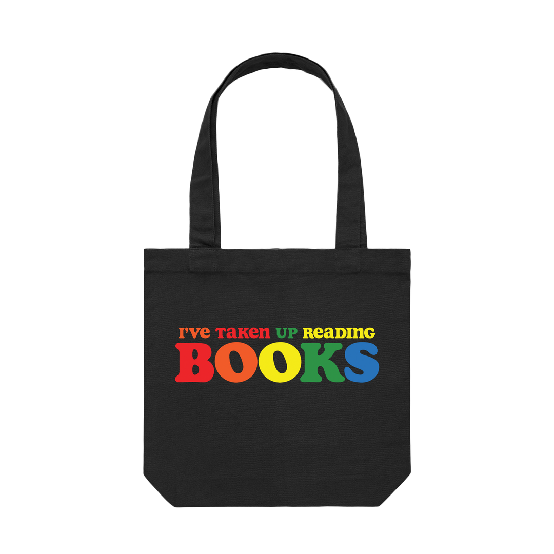 Black tote bag with the phrase "I've taken up reading books" printed in multiple colors on the front